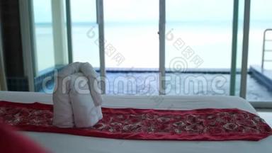 豪华酒店客房配有白色床上用品、按摩浴缸和前景大海。 欢迎度假村装饰。 毛巾
